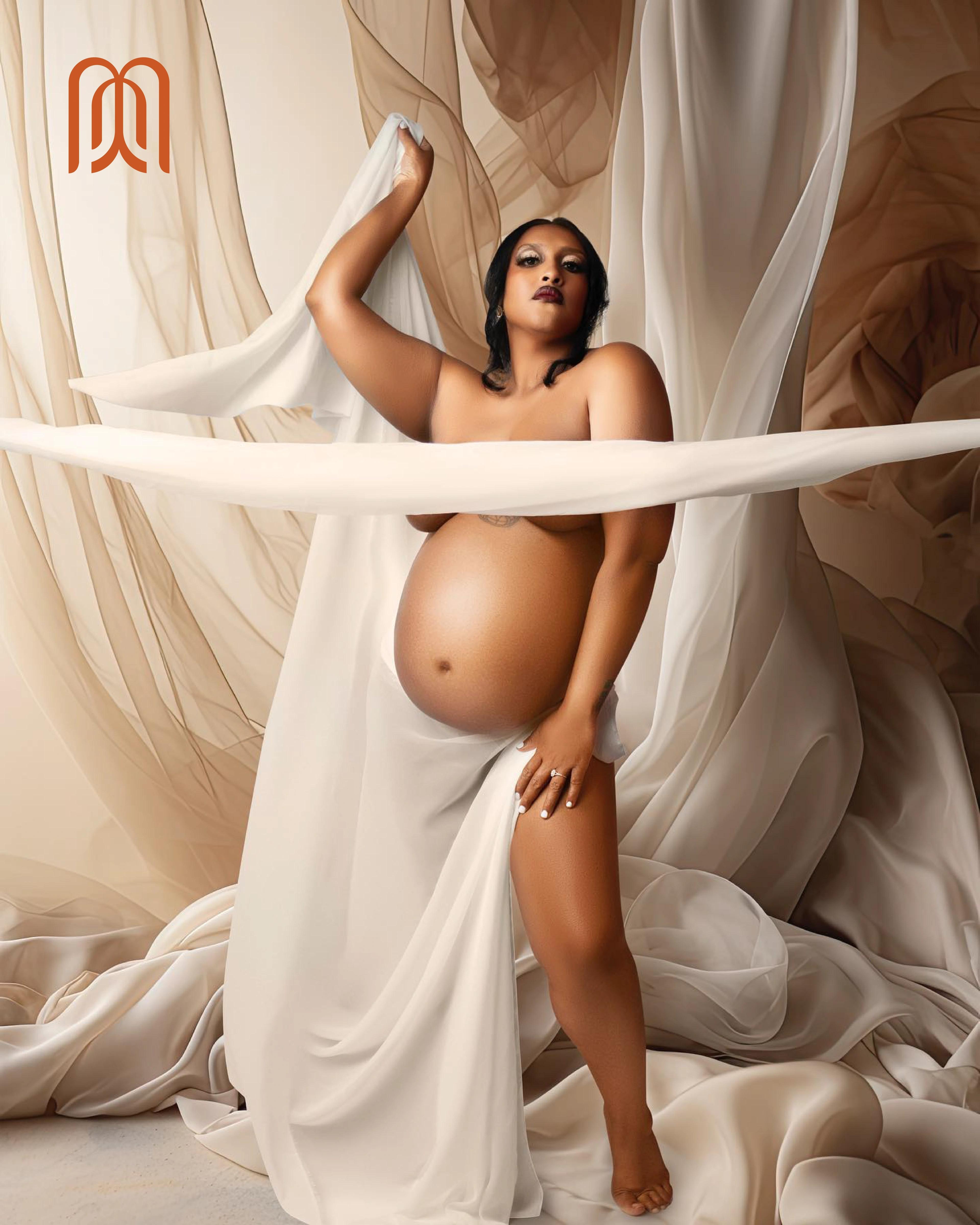 a maternity portrait of an expectant mother standing in sheer draped fabric, one arm raised