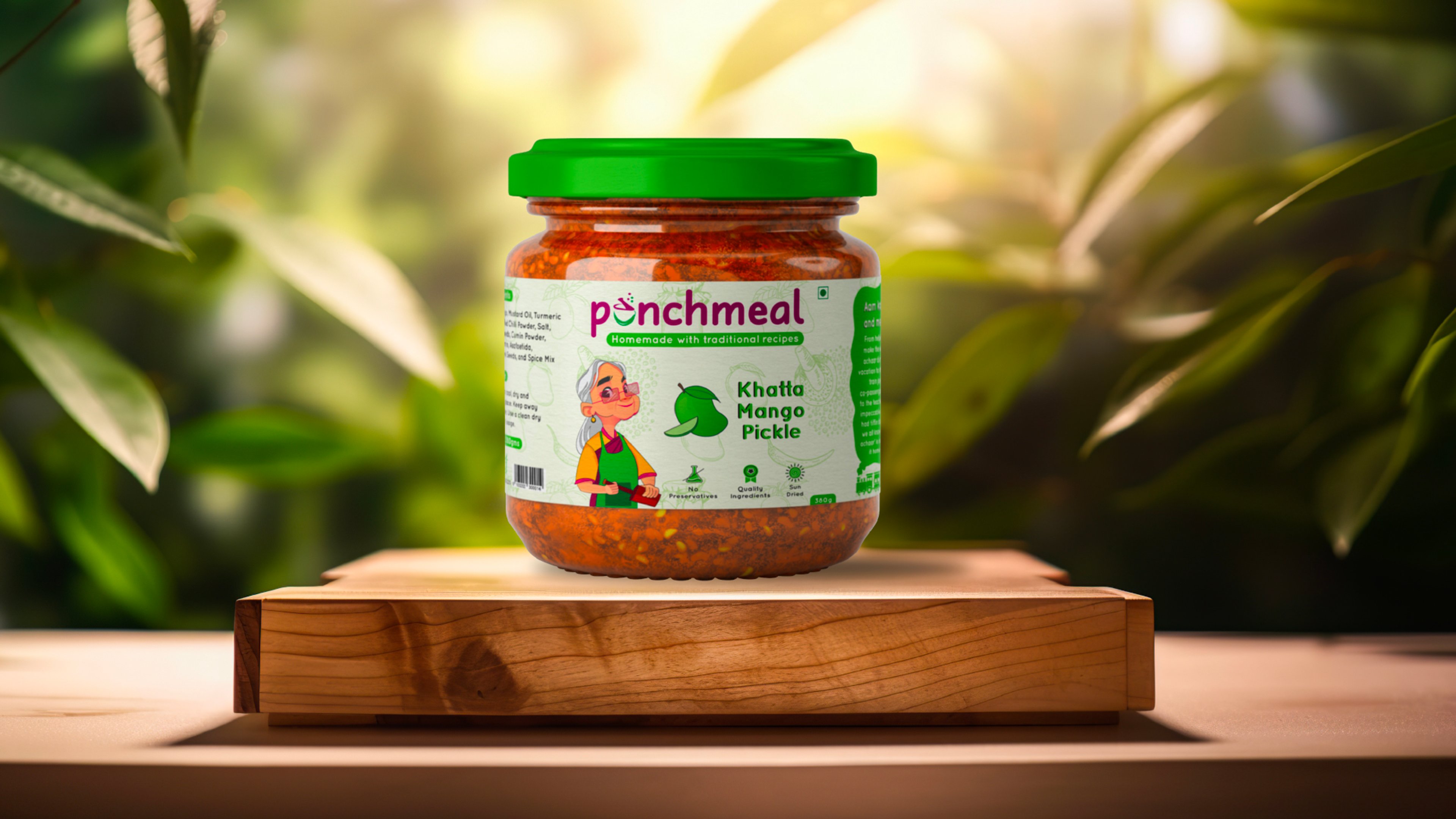Punchmeal Khatta Mango Pickle jar on a wooden block against sunlit green foliage