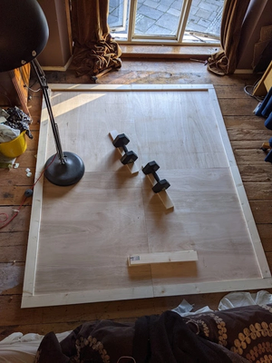 Boards on floor with weights and lamp on top