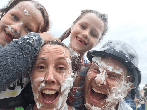 to adults and two children covered in foam