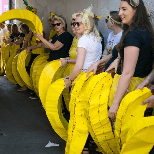 line of people holding giant bananas