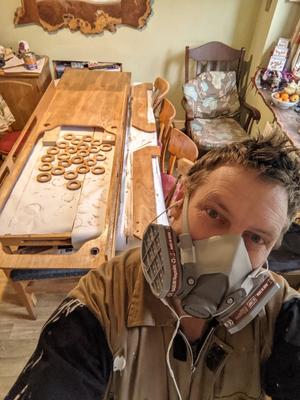 man wearing air filter mask in front of wood