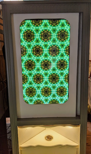 Vertical screen showing a repeated pattern in cabinet with a light and circle slot underneath