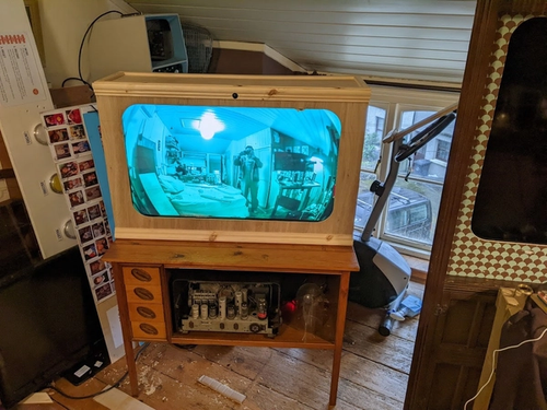Screen displaying blue tinted webcam footage in cabinet