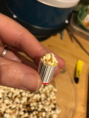 hand holding tiny popcorn container