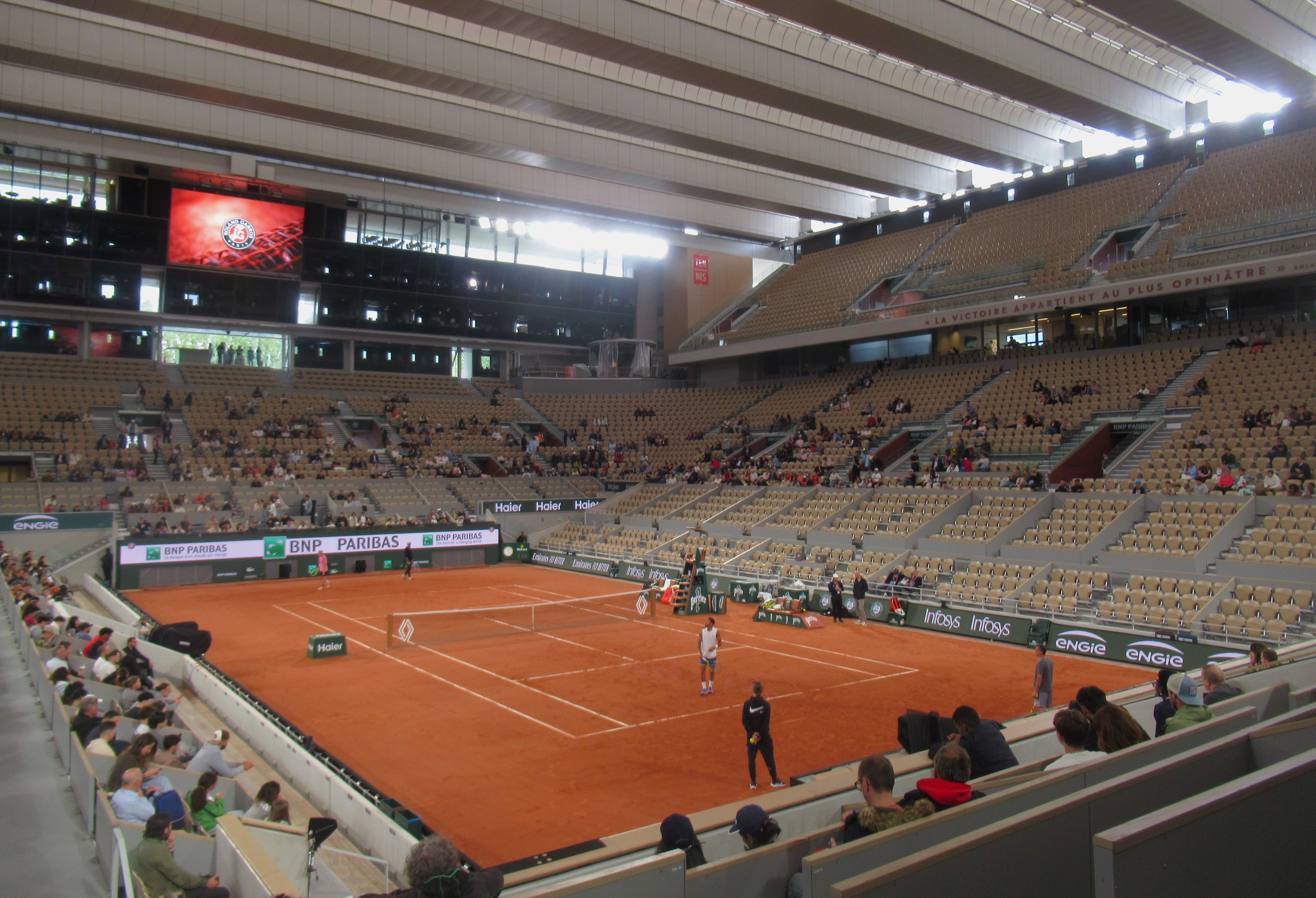 A match on the red clay of Court Philippe-Chatrier, with the stands under its roof structure