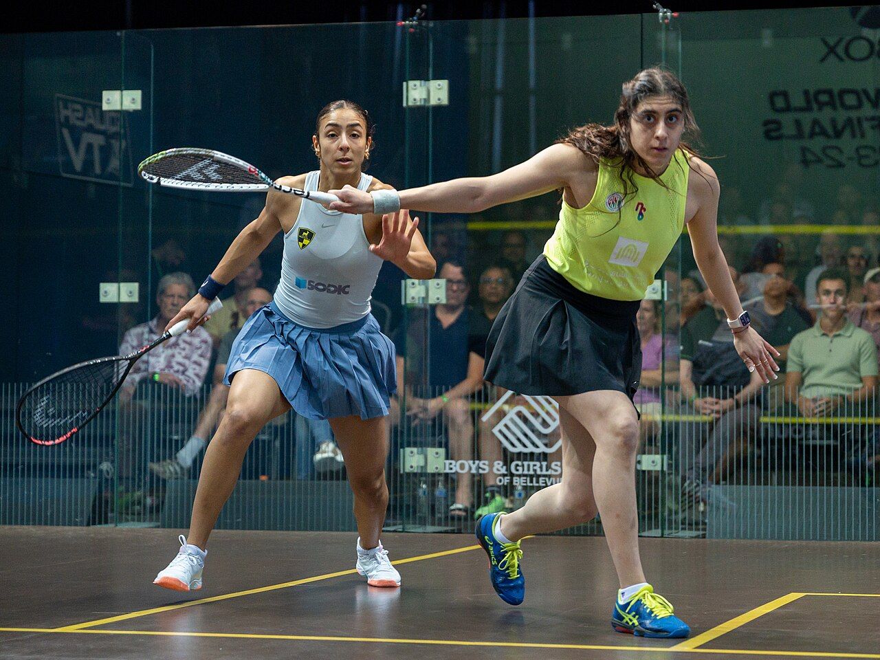 Nour ElSherbini (right, in yellow) playing Hania El Hammamy at the 2023-24 PSA World Tour Finals