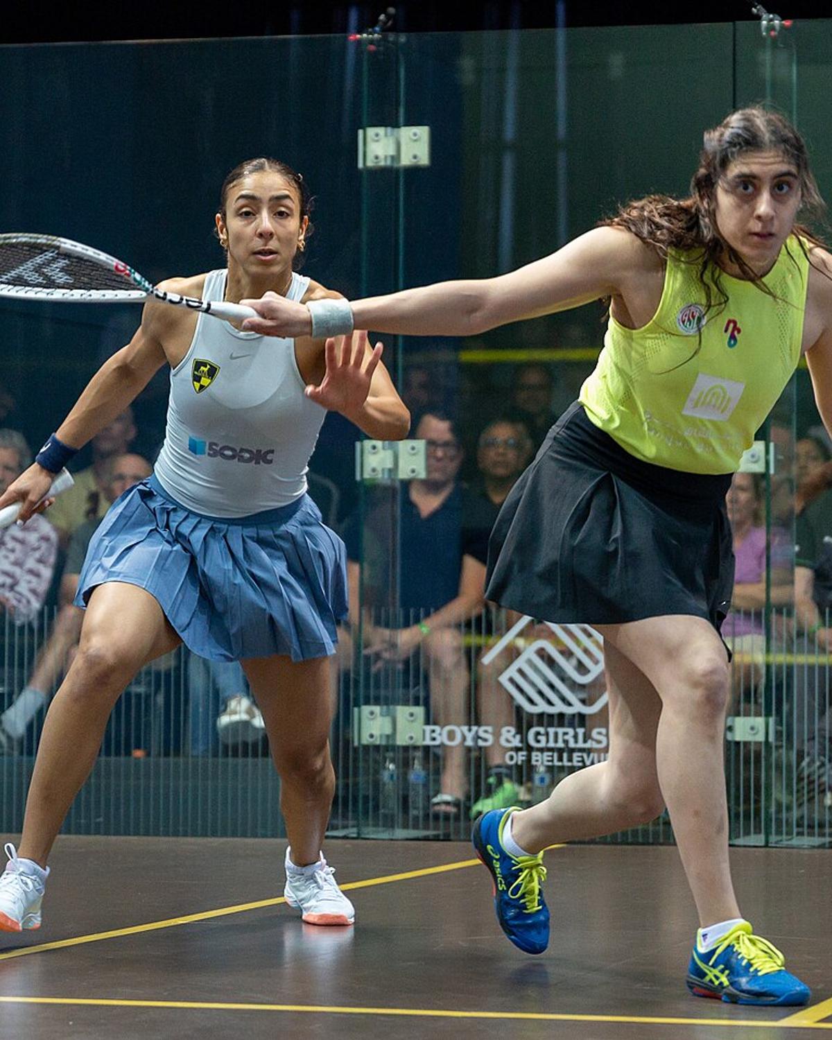 Nour ElSherbini (right, in yellow) playing Hania El Hammamy at the 2023-24 PSA World Tour Finals