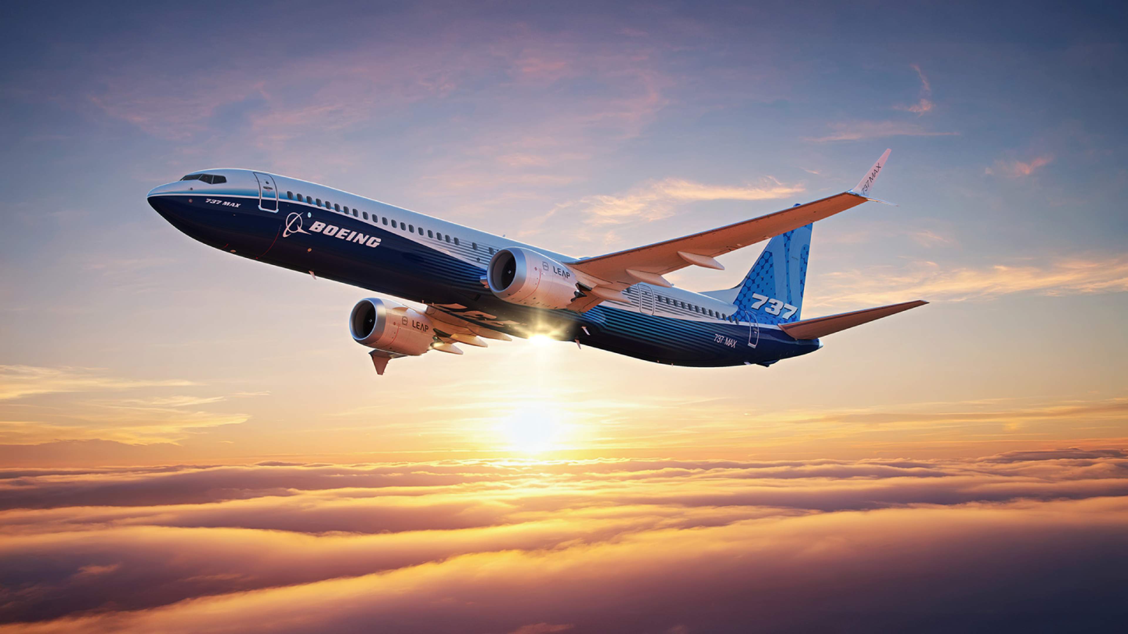 Boeing 737-10 in manufacturer livery flying above clouds