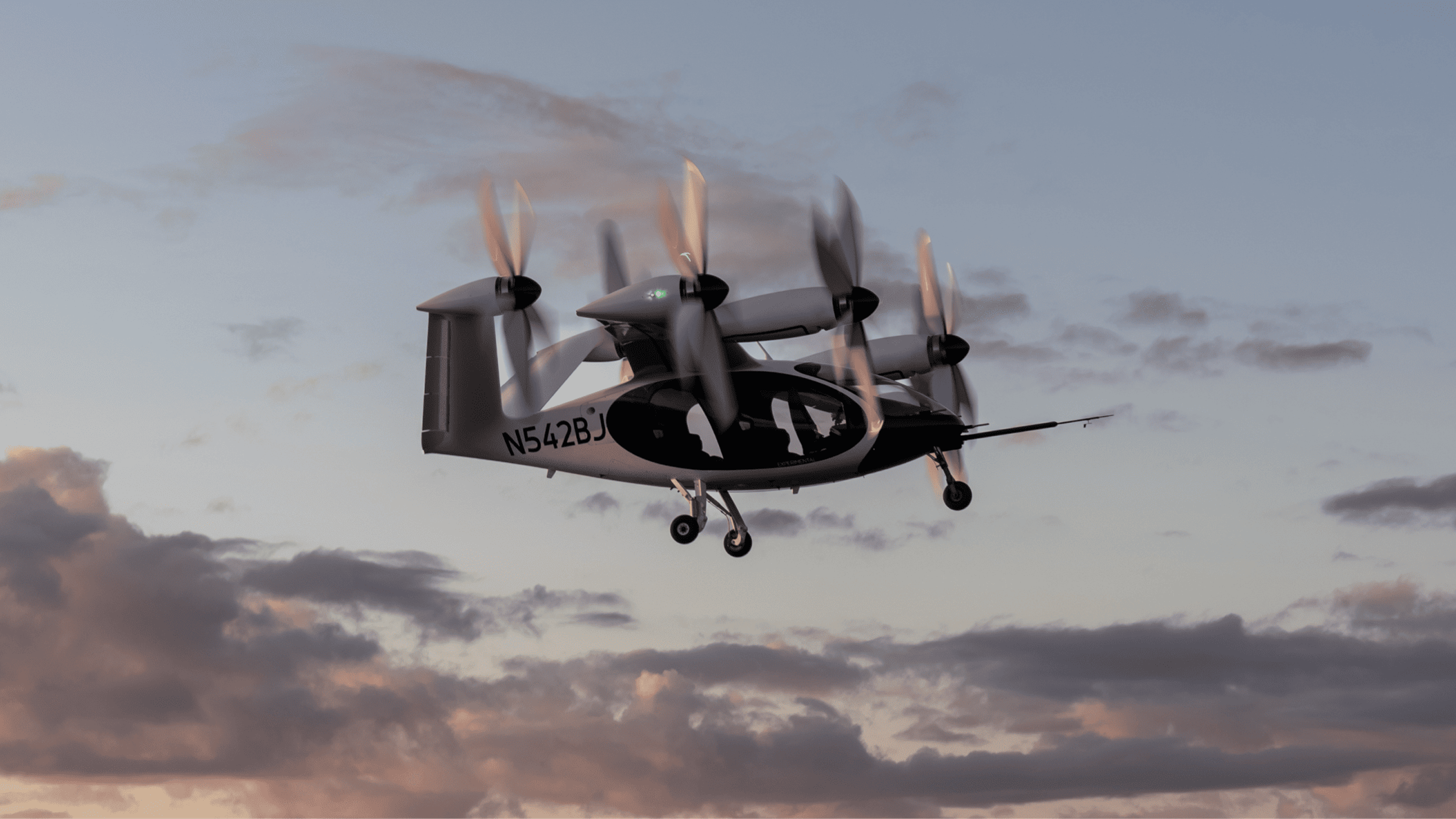 Joby electric vertical takeoff and landing aircraft in flight with its propellers in vertical-lift position