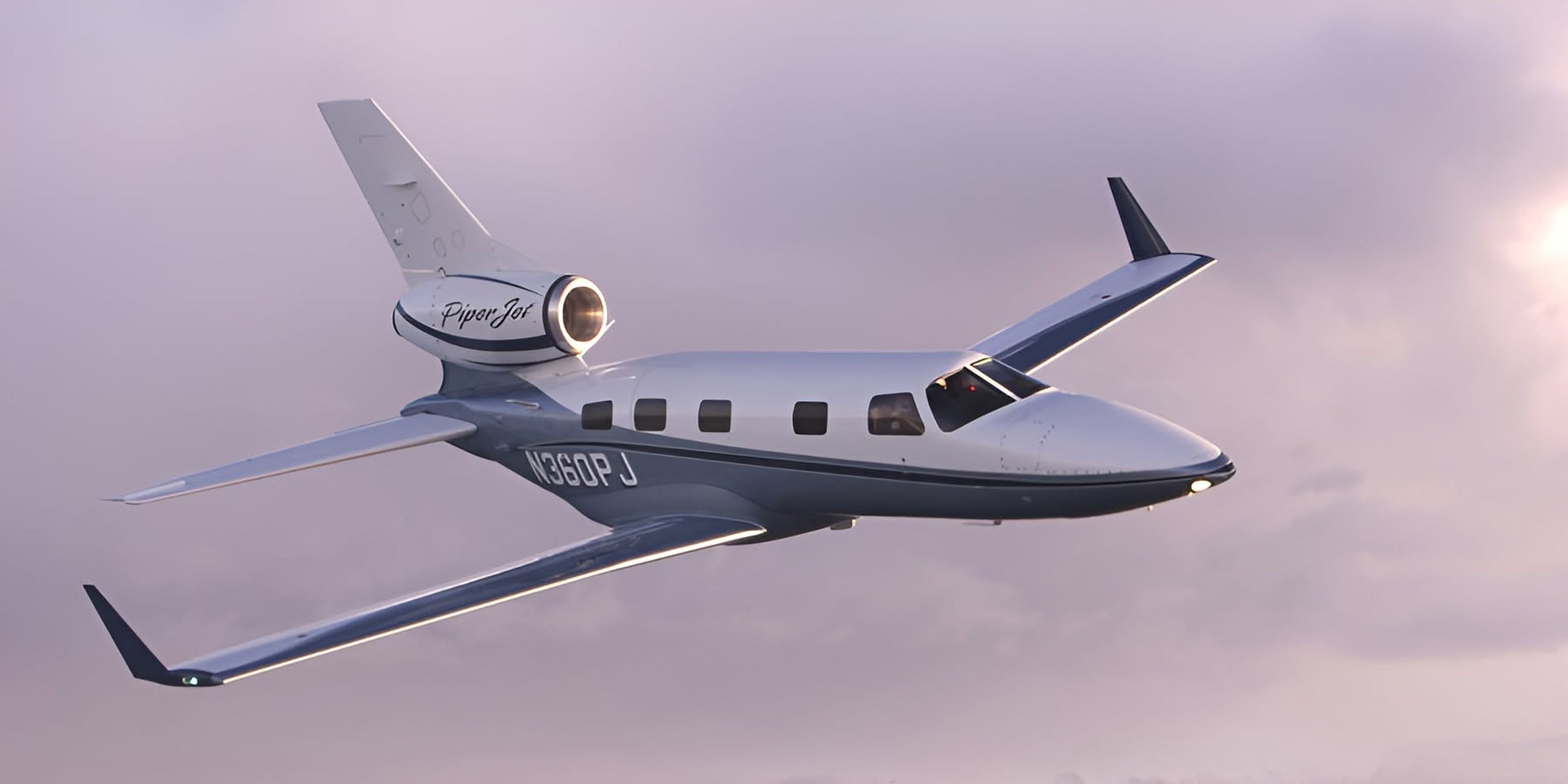 Piper PA-47 PiperJet prototype N360PJ in flight, showing its single tail-mounted engine against a purple sky.