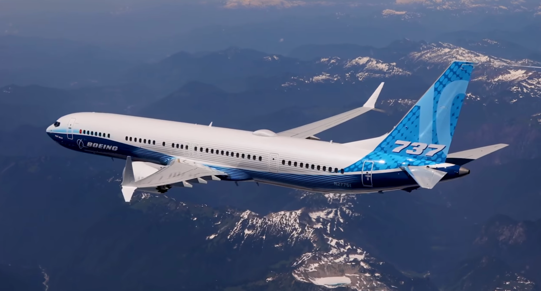 Boeing 737-10 test aircraft flying above a mountain landscape