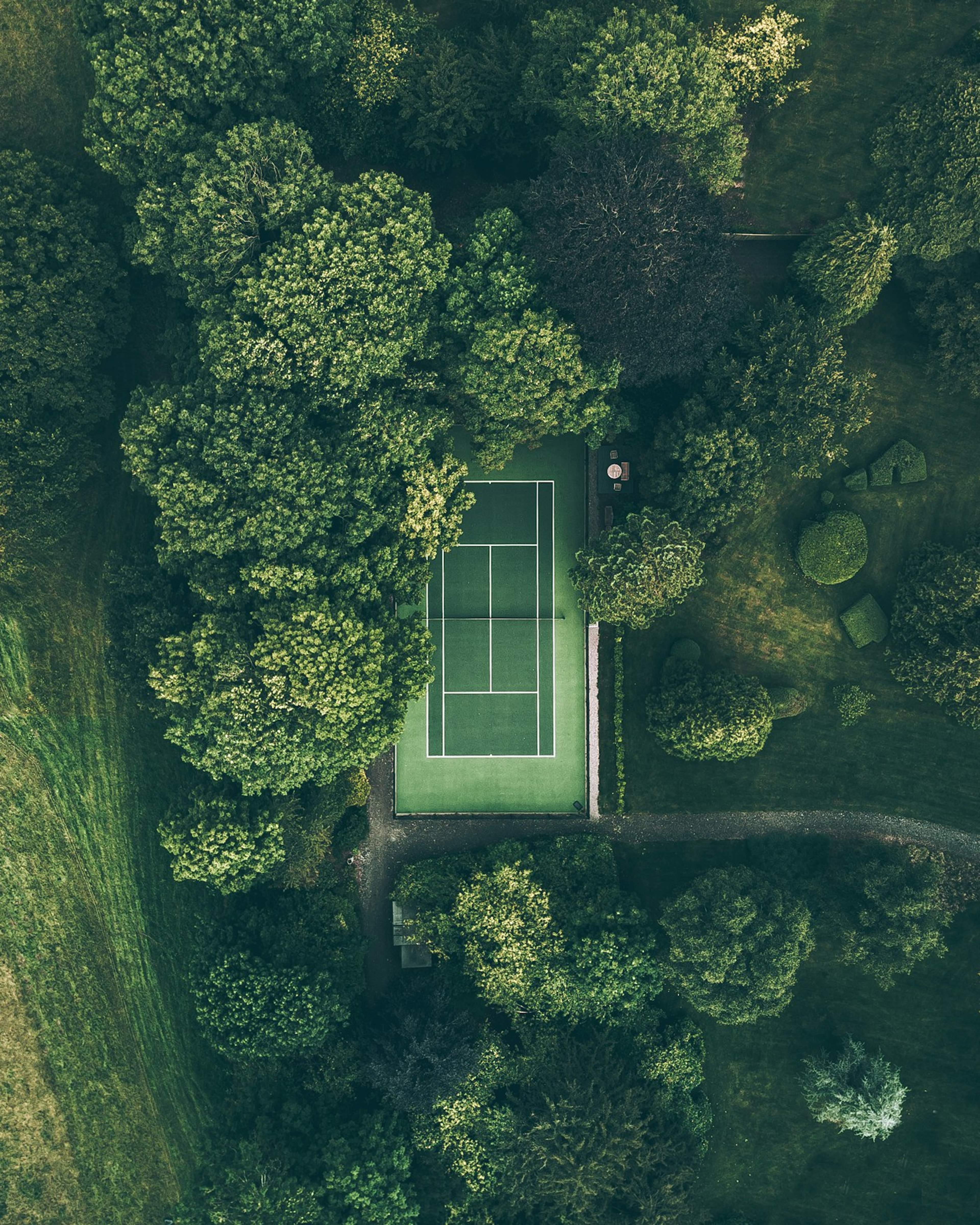 Tennis courts surrounded by trees seen from above