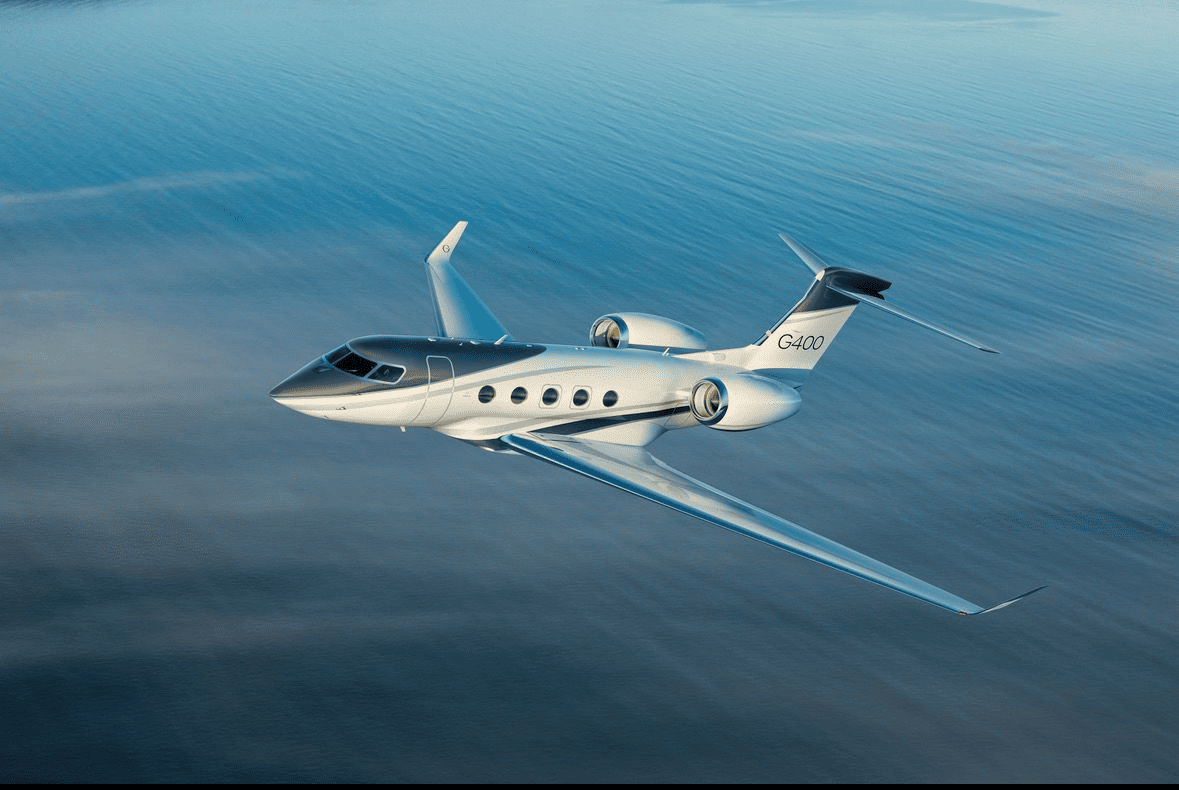 Gulfstream G400 business jet shown banking above blue water
