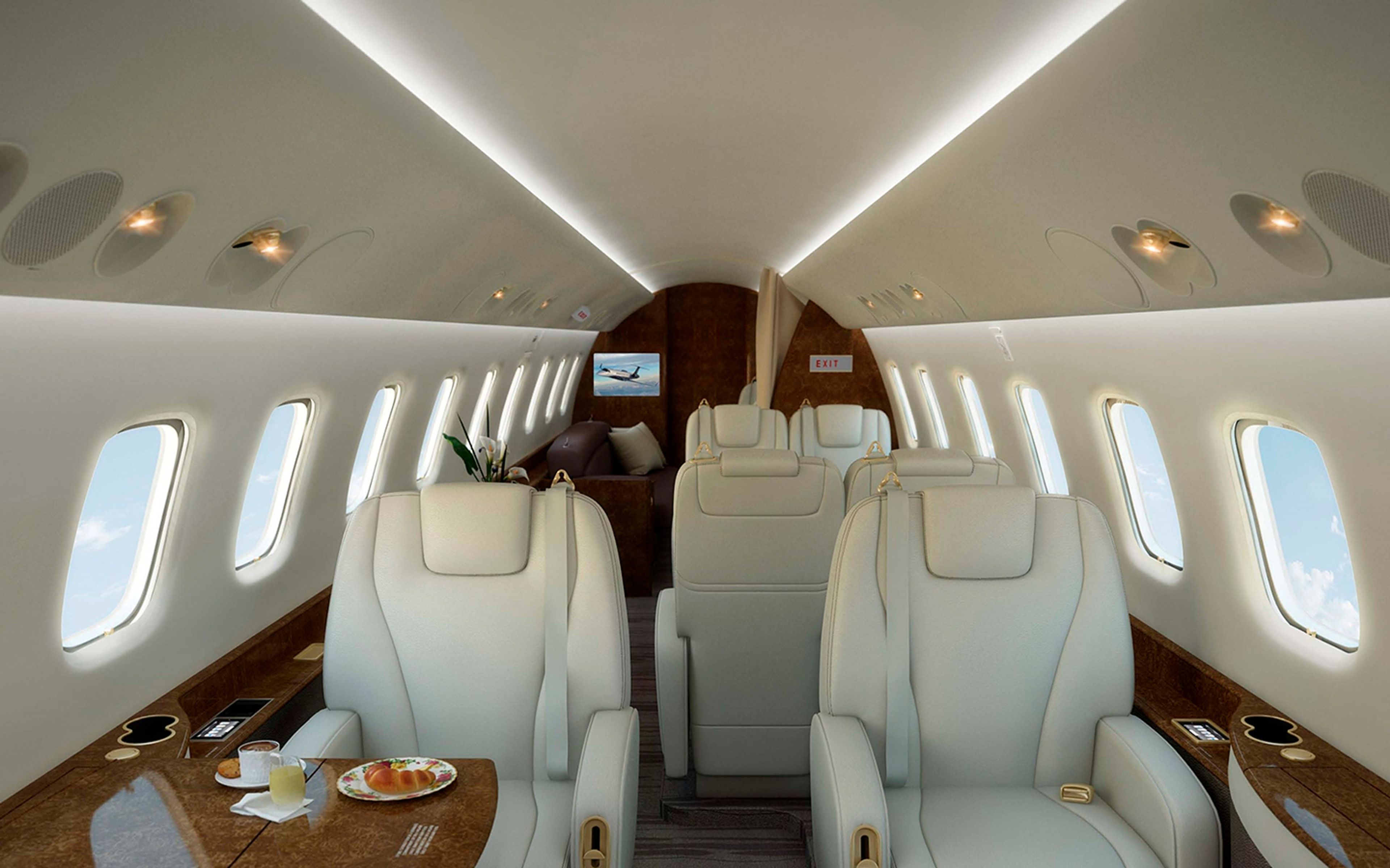 Legacy 600/650-family cabin with cream leather seats, wood trim and indirect ceiling lighting.