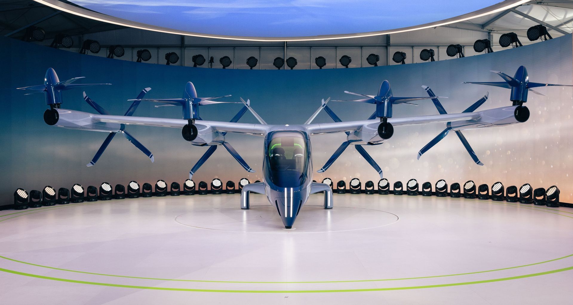 A piloted eVTOL aircraft on an urban vertiport at dusk