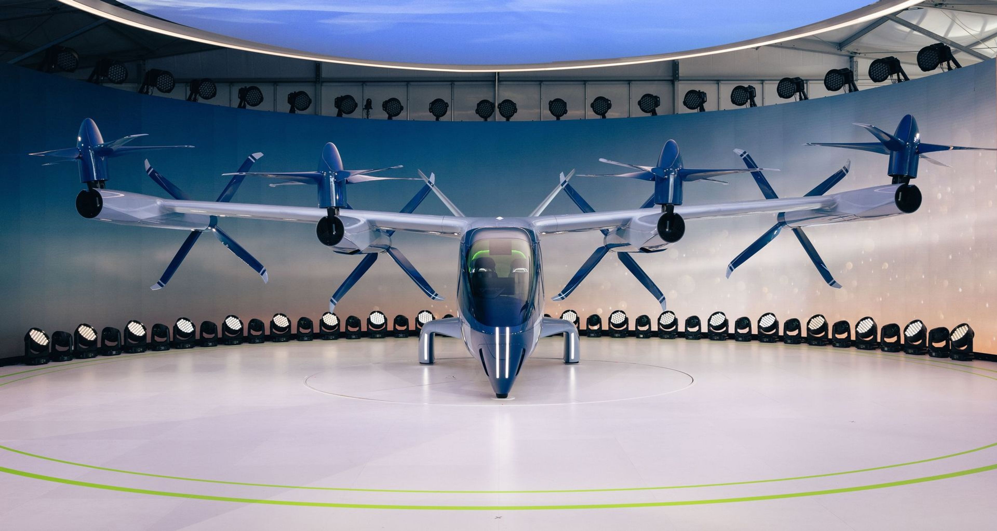 A piloted eVTOL aircraft on an urban vertiport at dusk