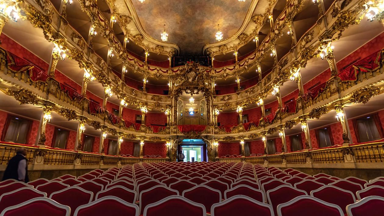 The interior of the Cuvilliés Theater in Munich Photographed from the stage you can see the chairs in red velvet in in the background the barock ranks in gold and red and the marmorized ceiling