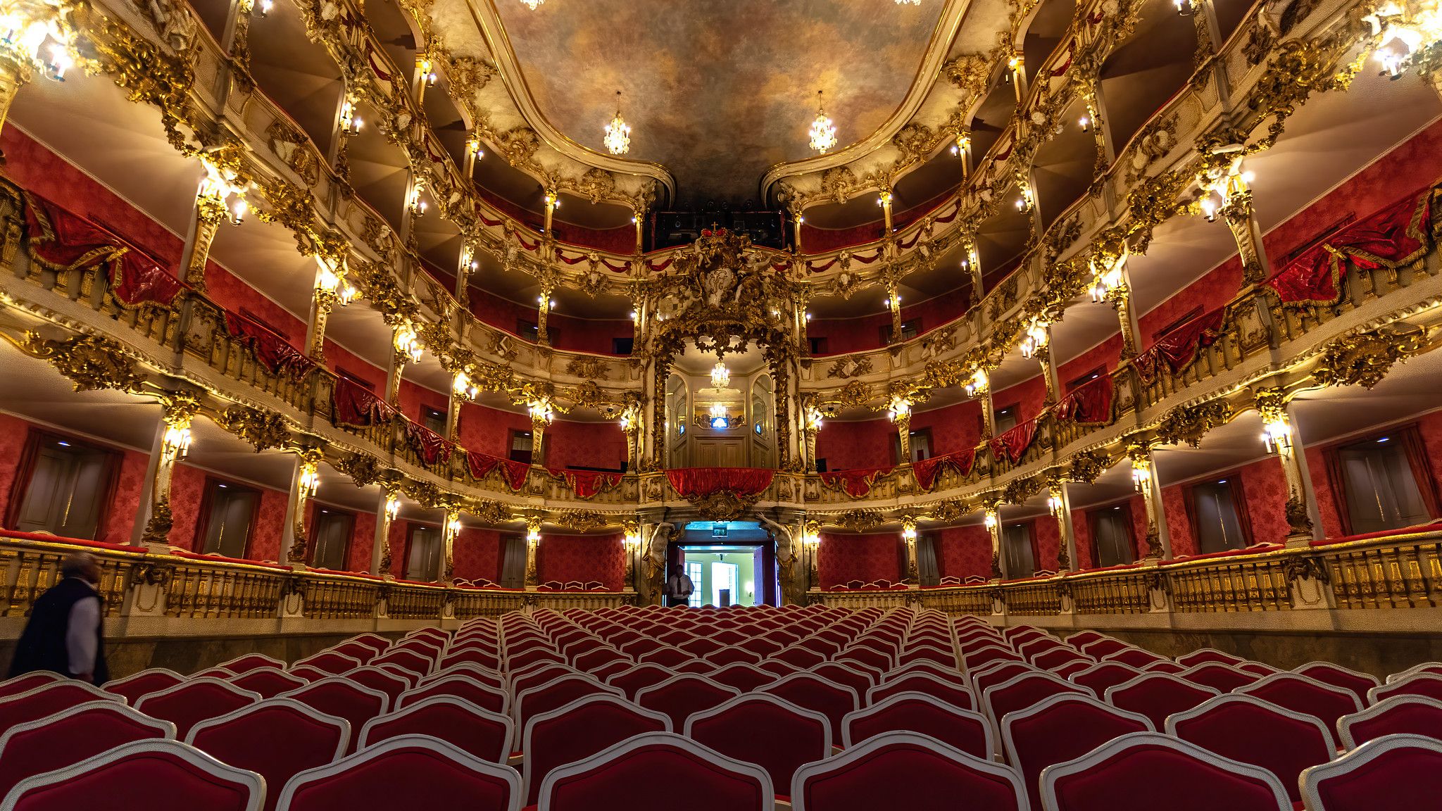 The interior of the Cuvilliés Theater in Munich Photographed from the stage you can see the chairs in red velvet in in the background the barock ranks in gold and red and the marmorized ceiling