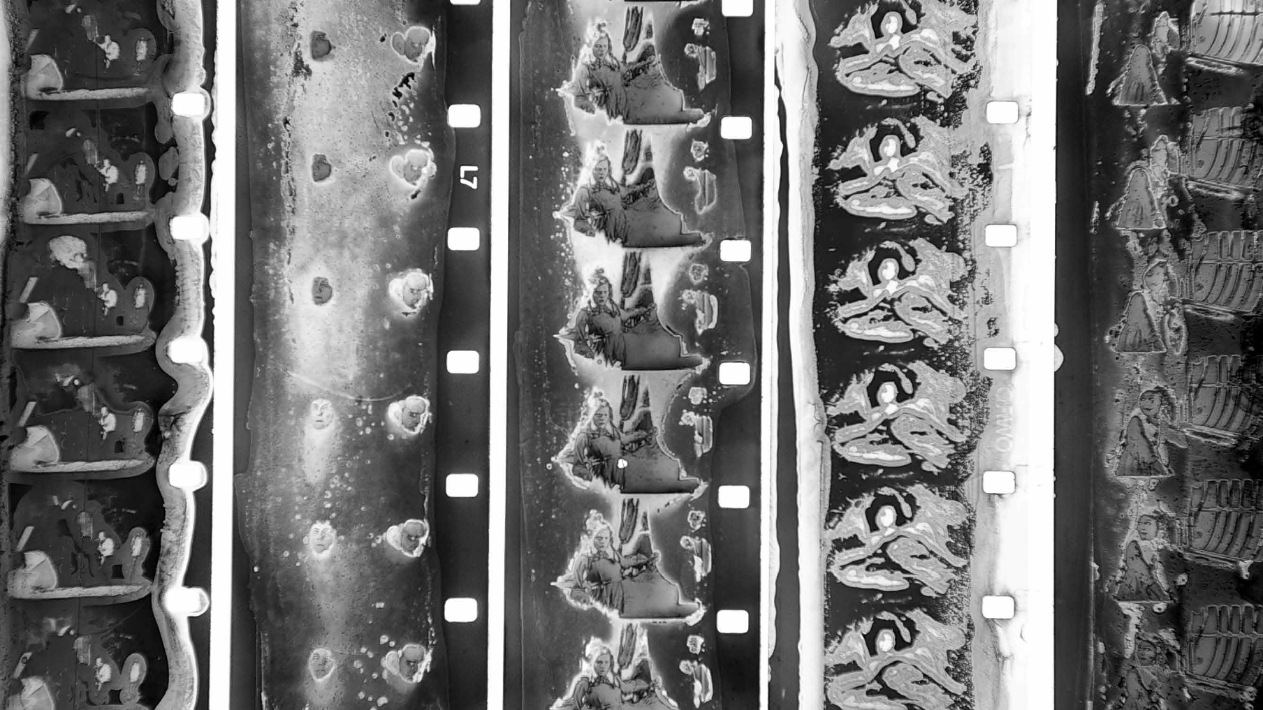 A black and white close-up of film negatives depicting human figures.