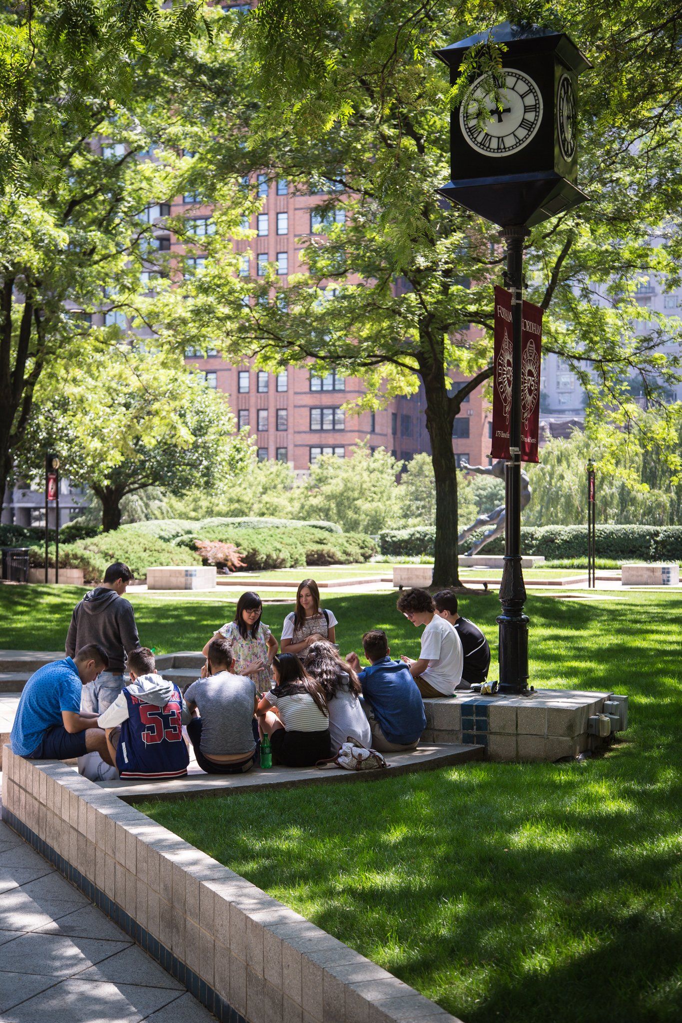 Students chatting in the shaded Lincoln Center campus garden