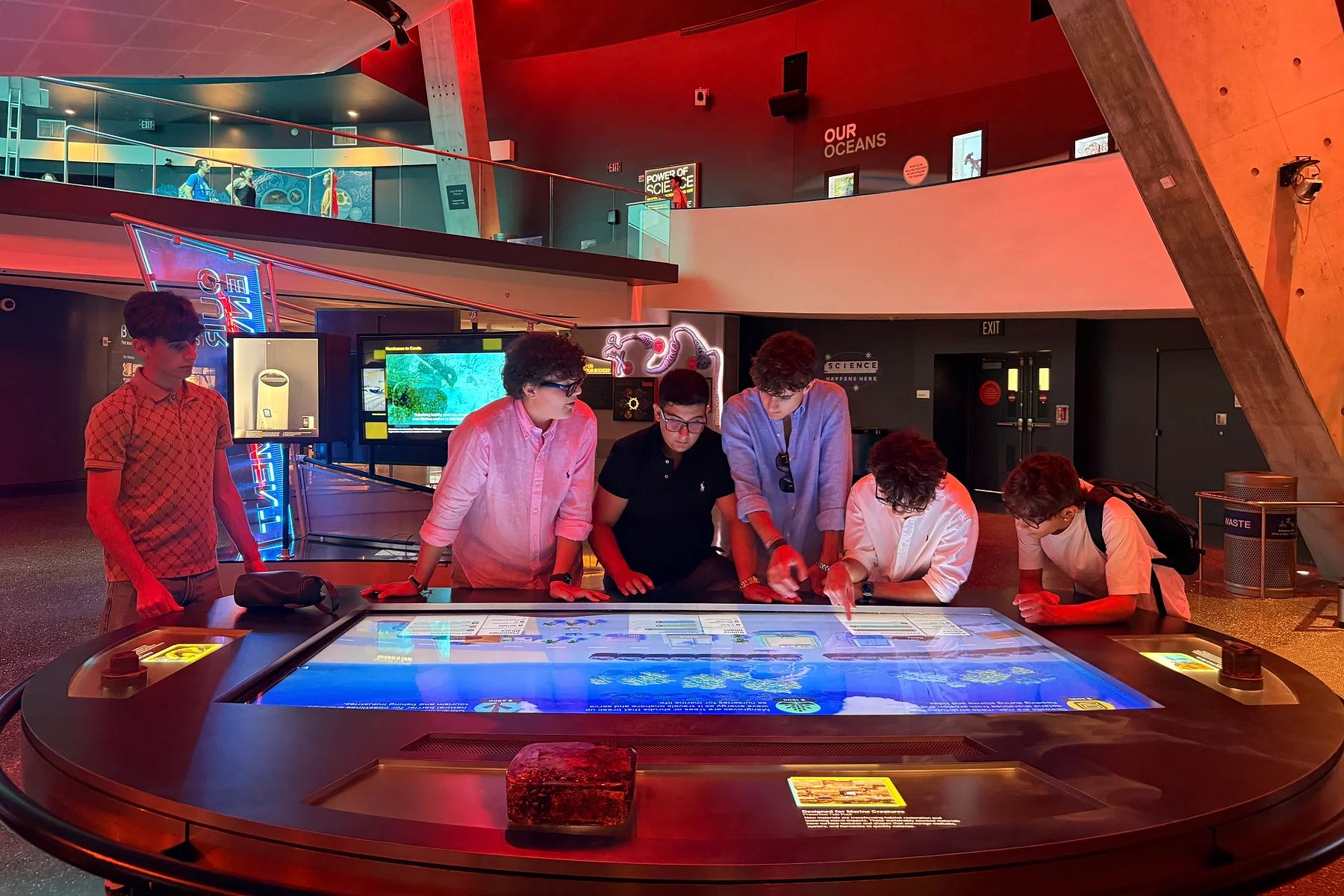 Students gathered around an interactive science exhibit