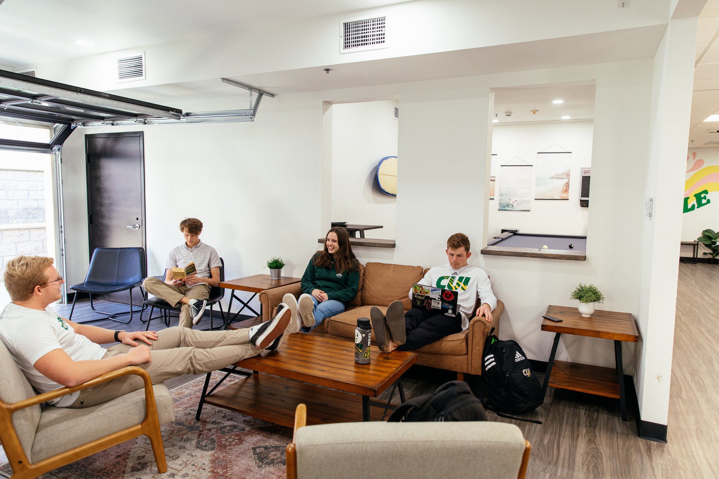 Students relaxing on sofas and armchairs in the Chi Sigma residence lounge at Concordia