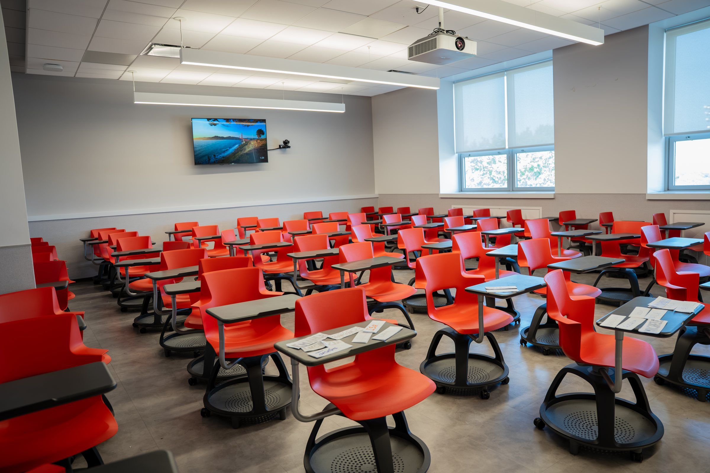 Bright classroom with red mobile chairs and a screen at St. John's