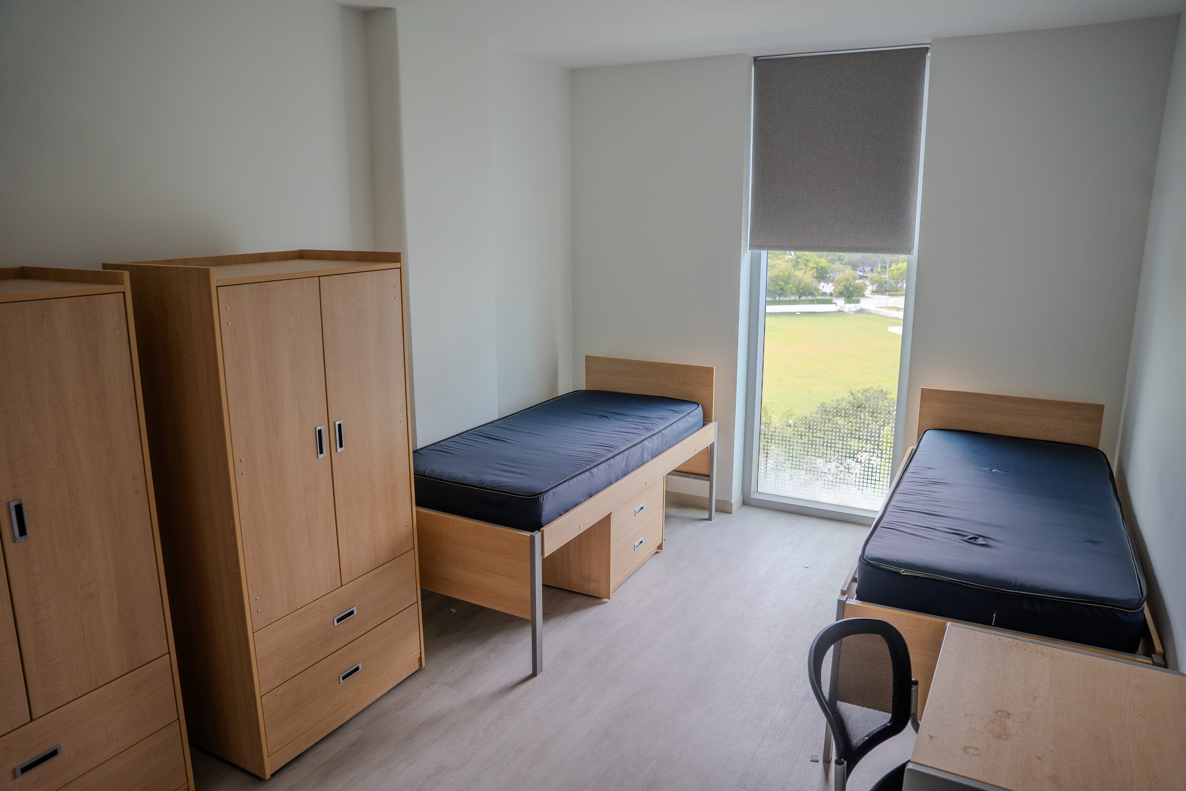 A double room at the University of Miami residence, with two beds, wardrobes and a large window
