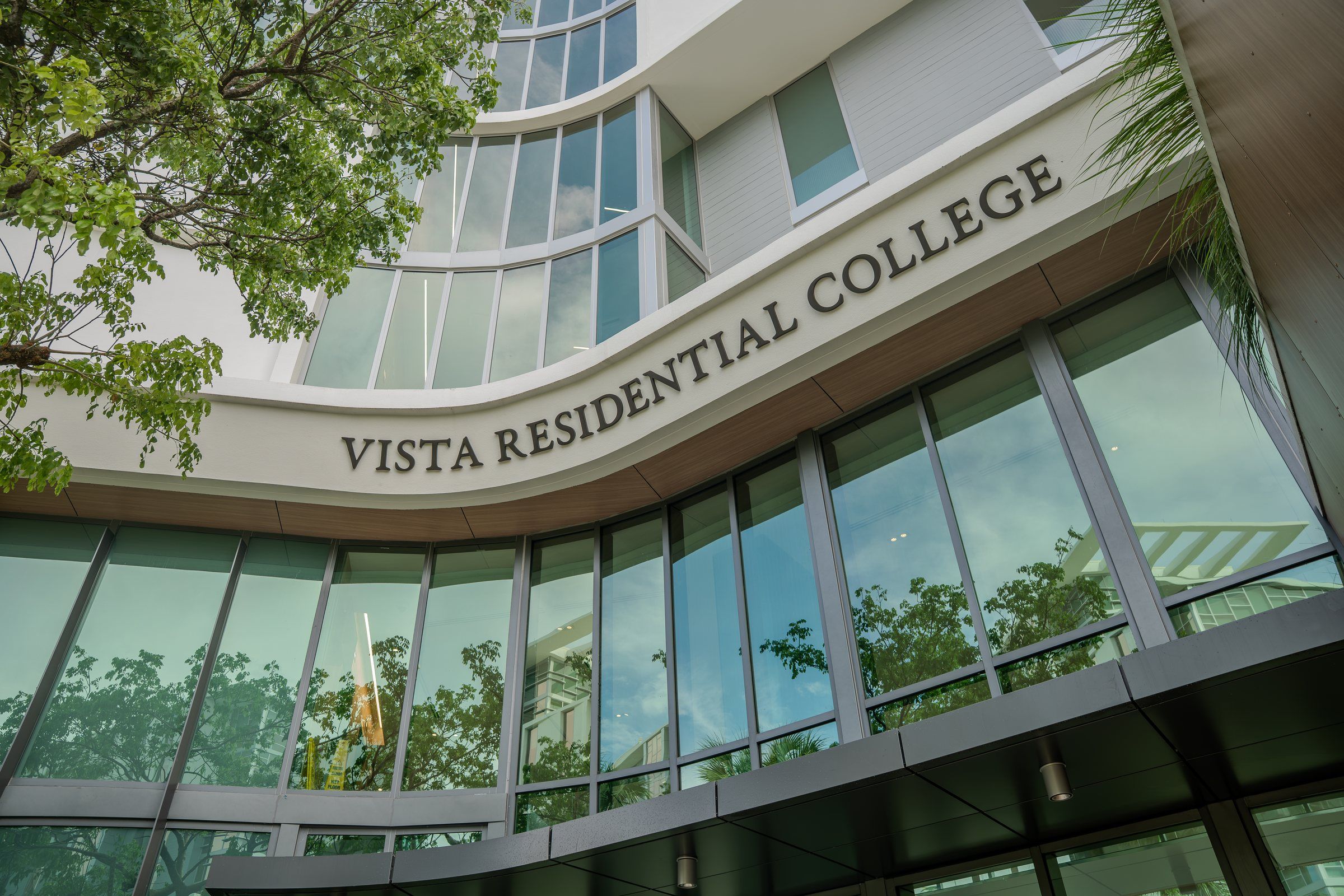 Curved glass entrance of Vista Residential College at the University of Miami