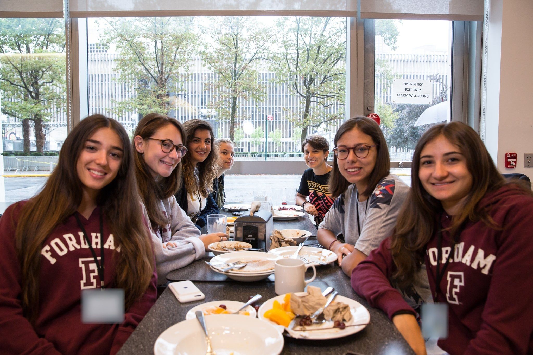 Smiling students at a breakfast table in the Fordham cafeteria