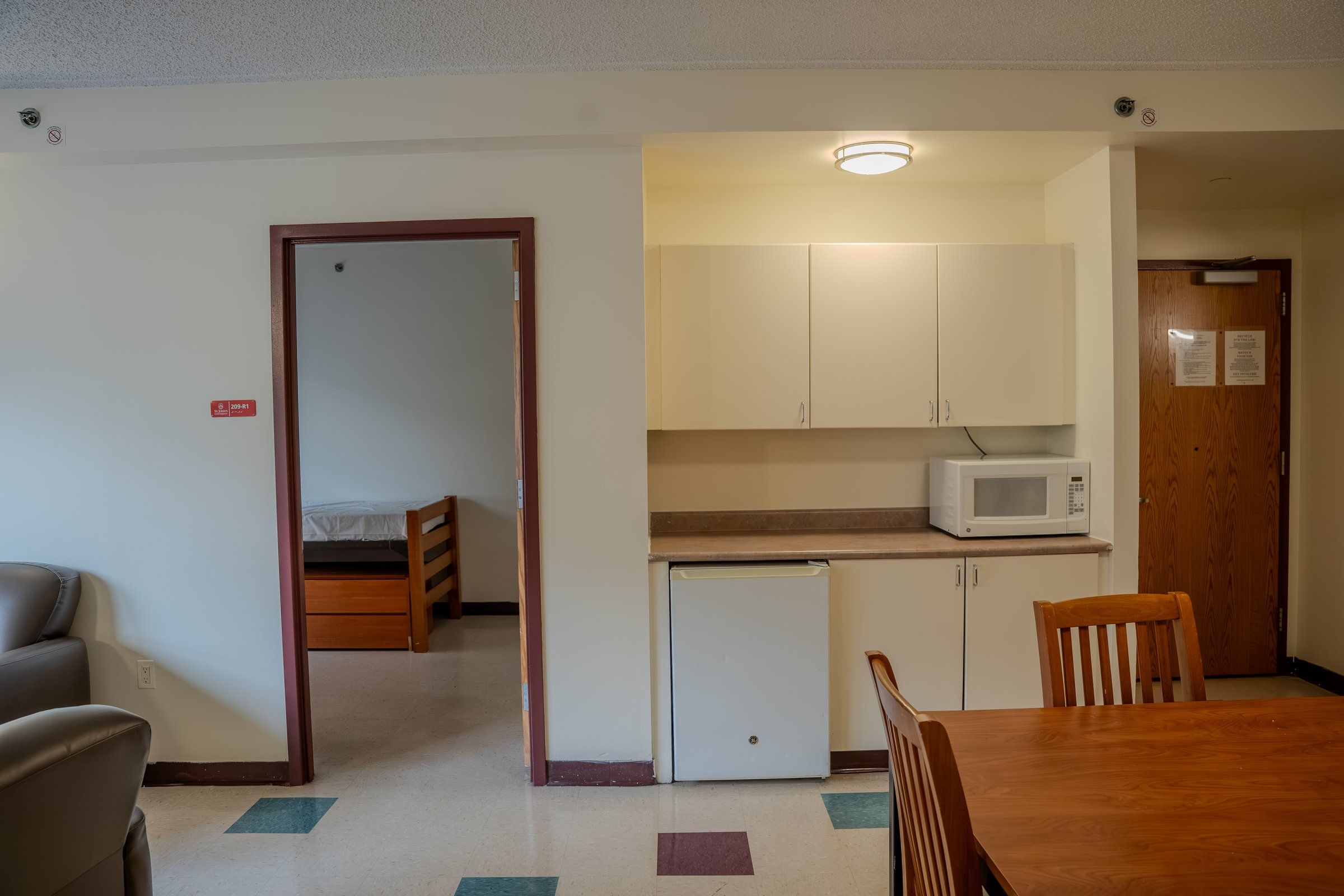 Suite kitchenette with cabinets, a microwave and a mini fridge at St. John's