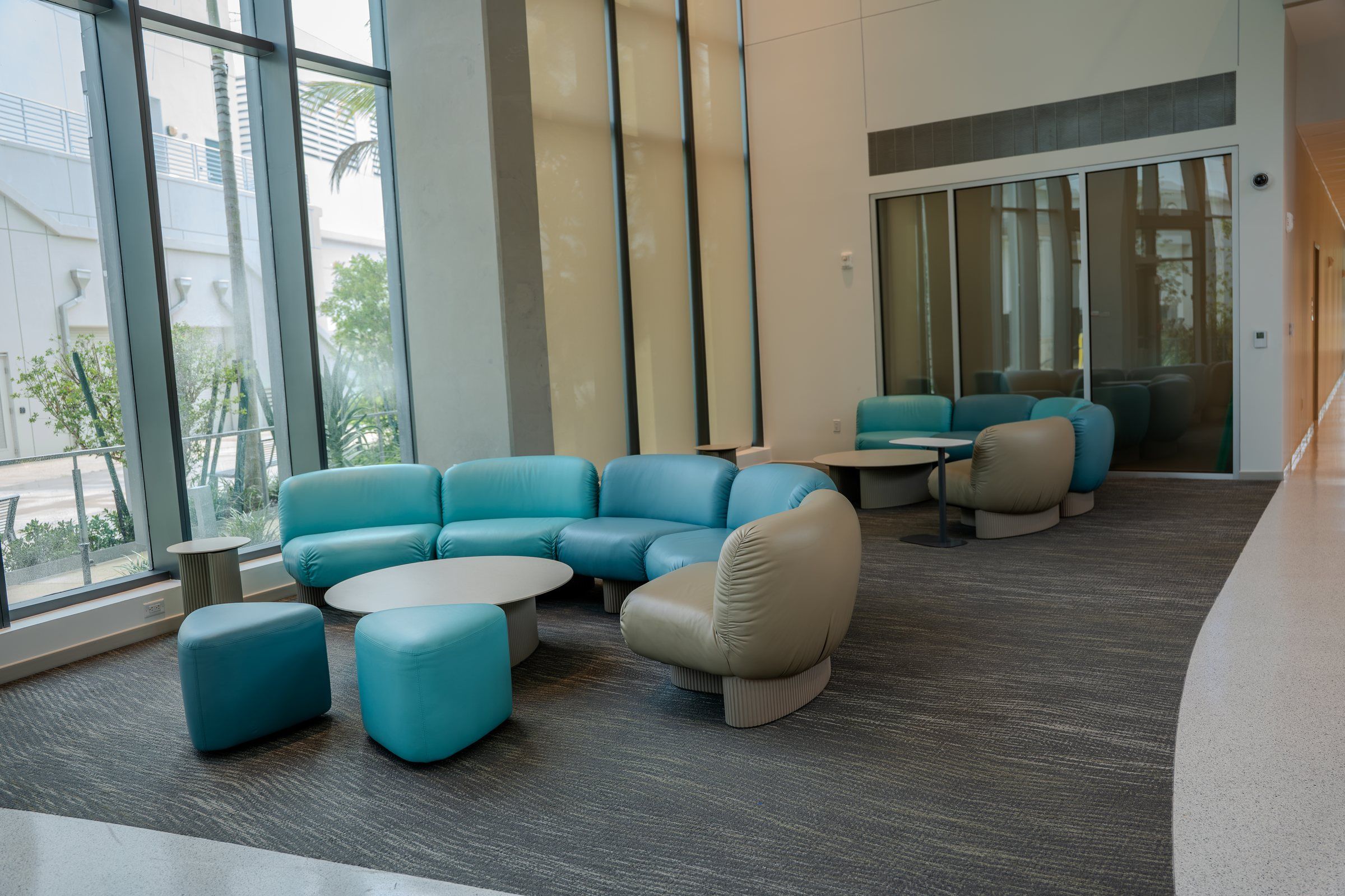 Residence lobby lounge with teal seating and floor-to-ceiling windows