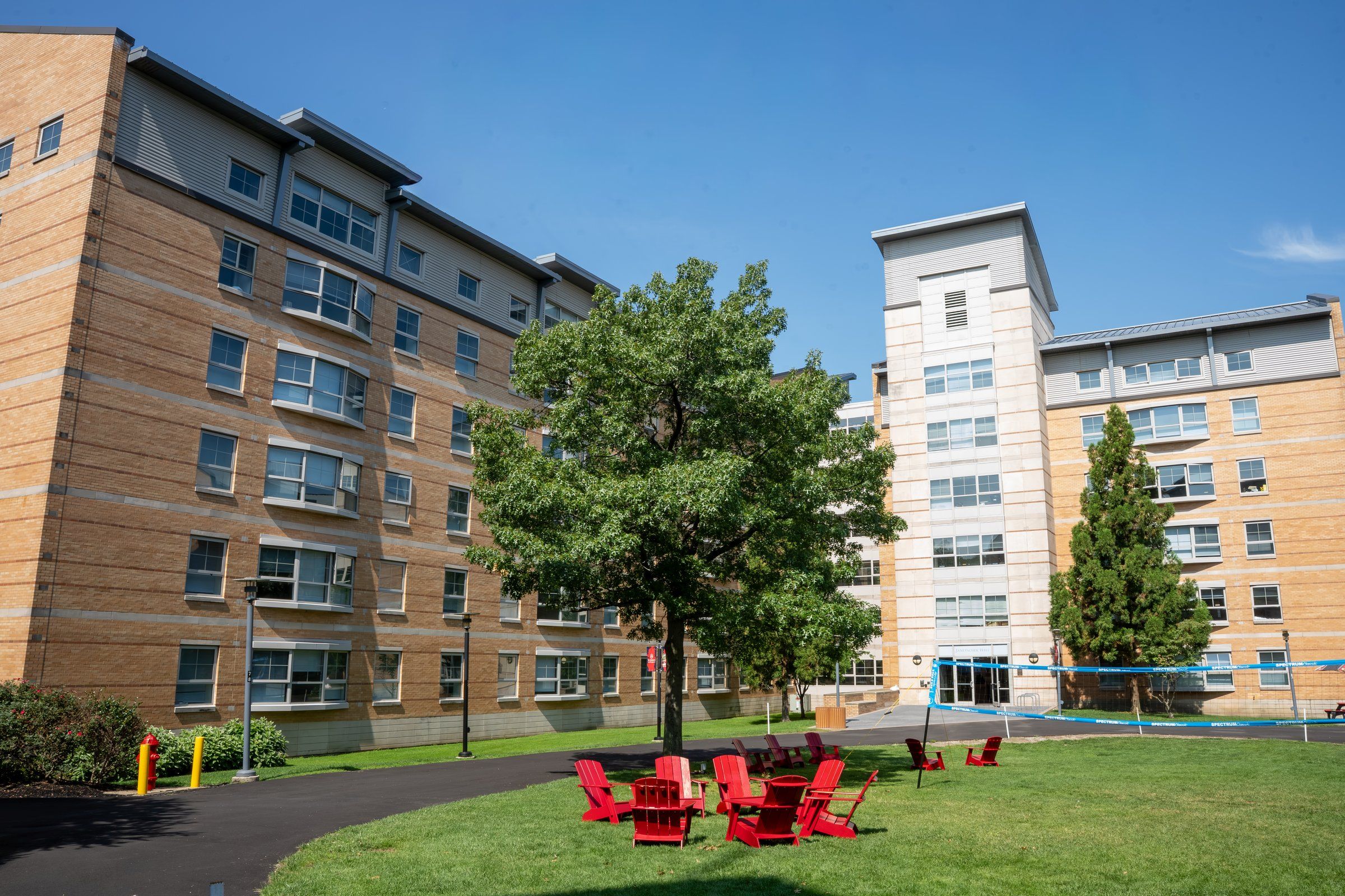 St. John's University residence halls around a green lawn with red Adirondack chairs