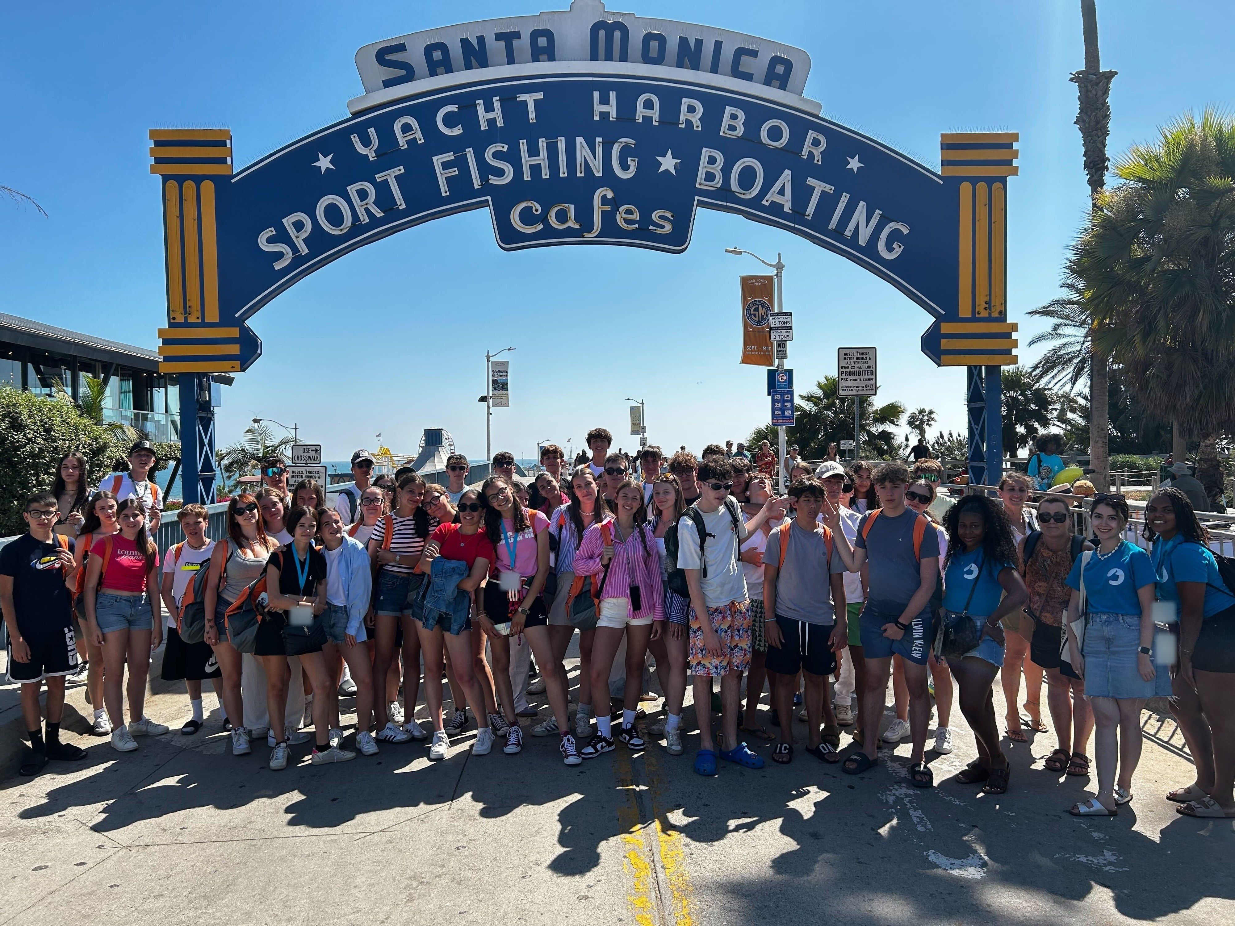 A large YES USA group under the Santa Monica Pier sign, Los Angeles
