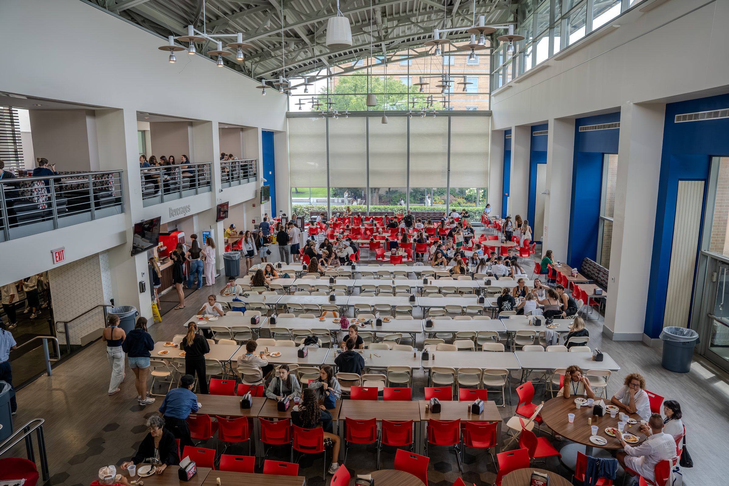 The main St. John's dining hall with red chairs under a glass atrium