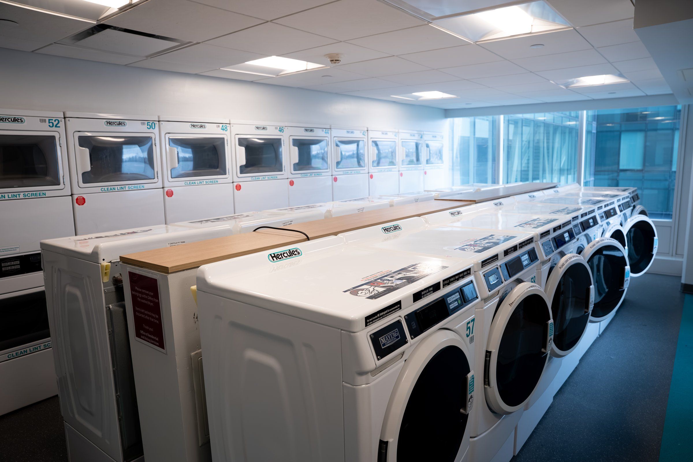 Washers and dryers in a bright laundry room used by students at Stevens