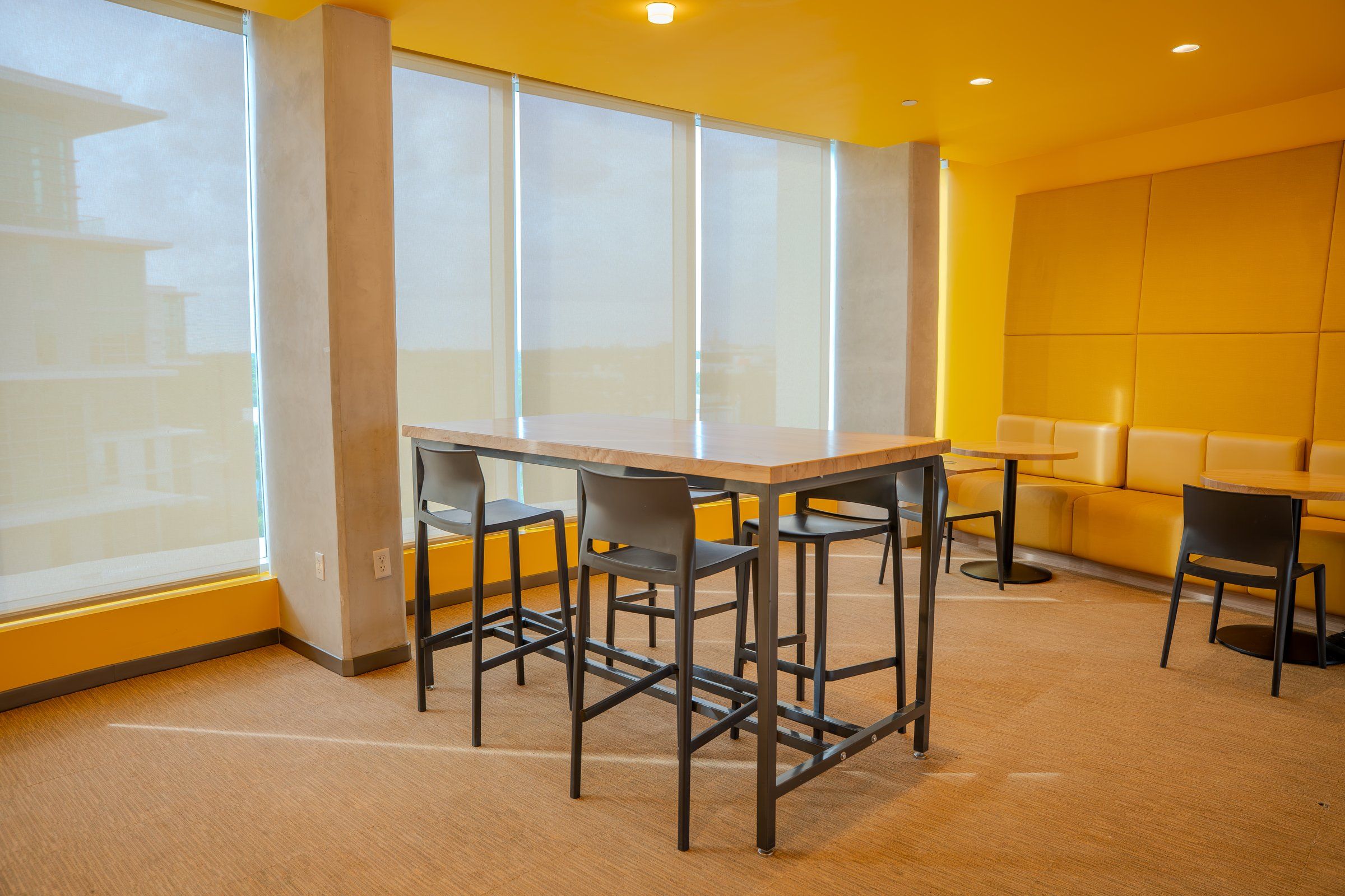 A bright common room with high tables in the University of Miami residence