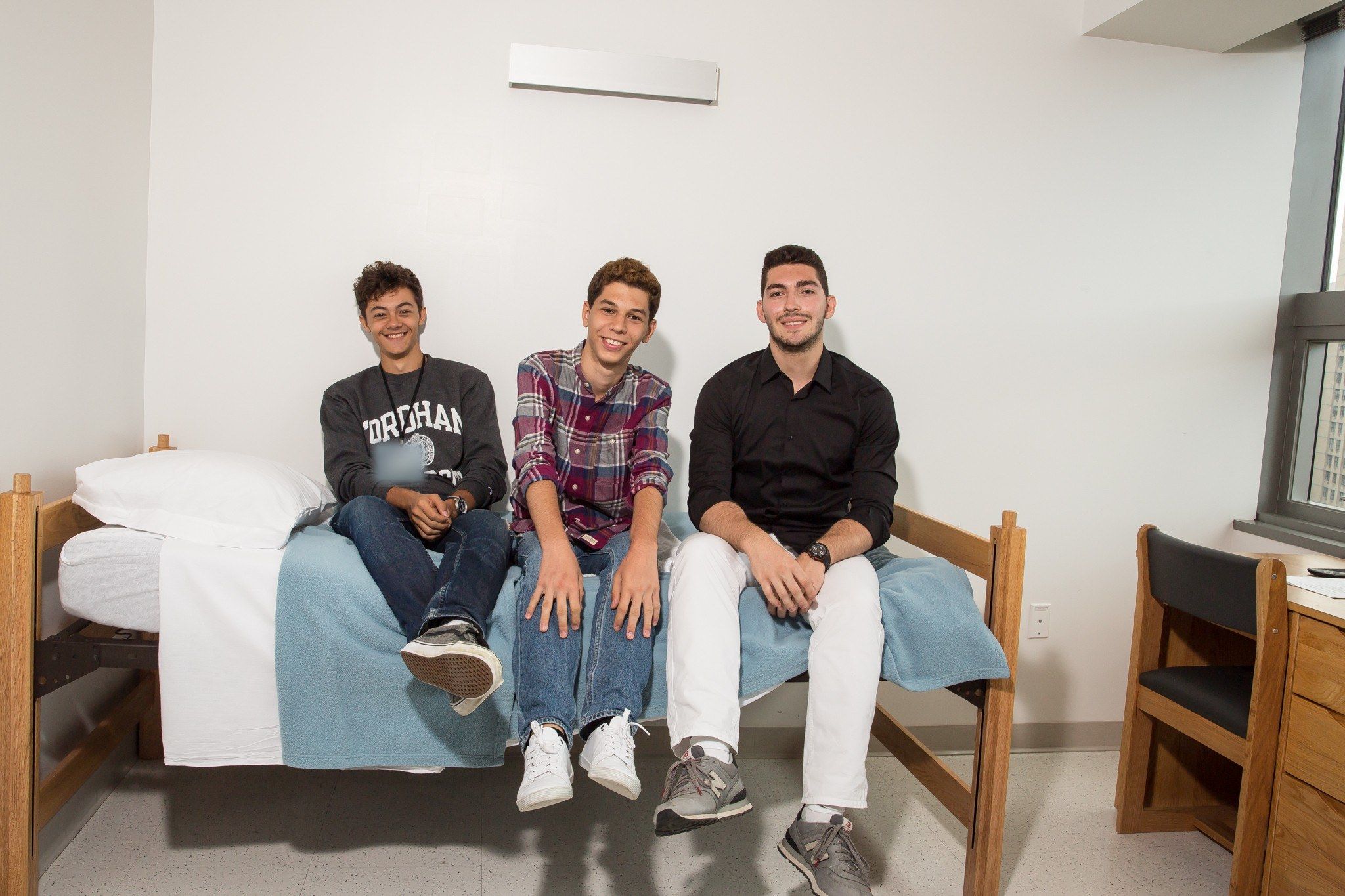 Three students smiling in a Fordham University at Lincoln Center residence room