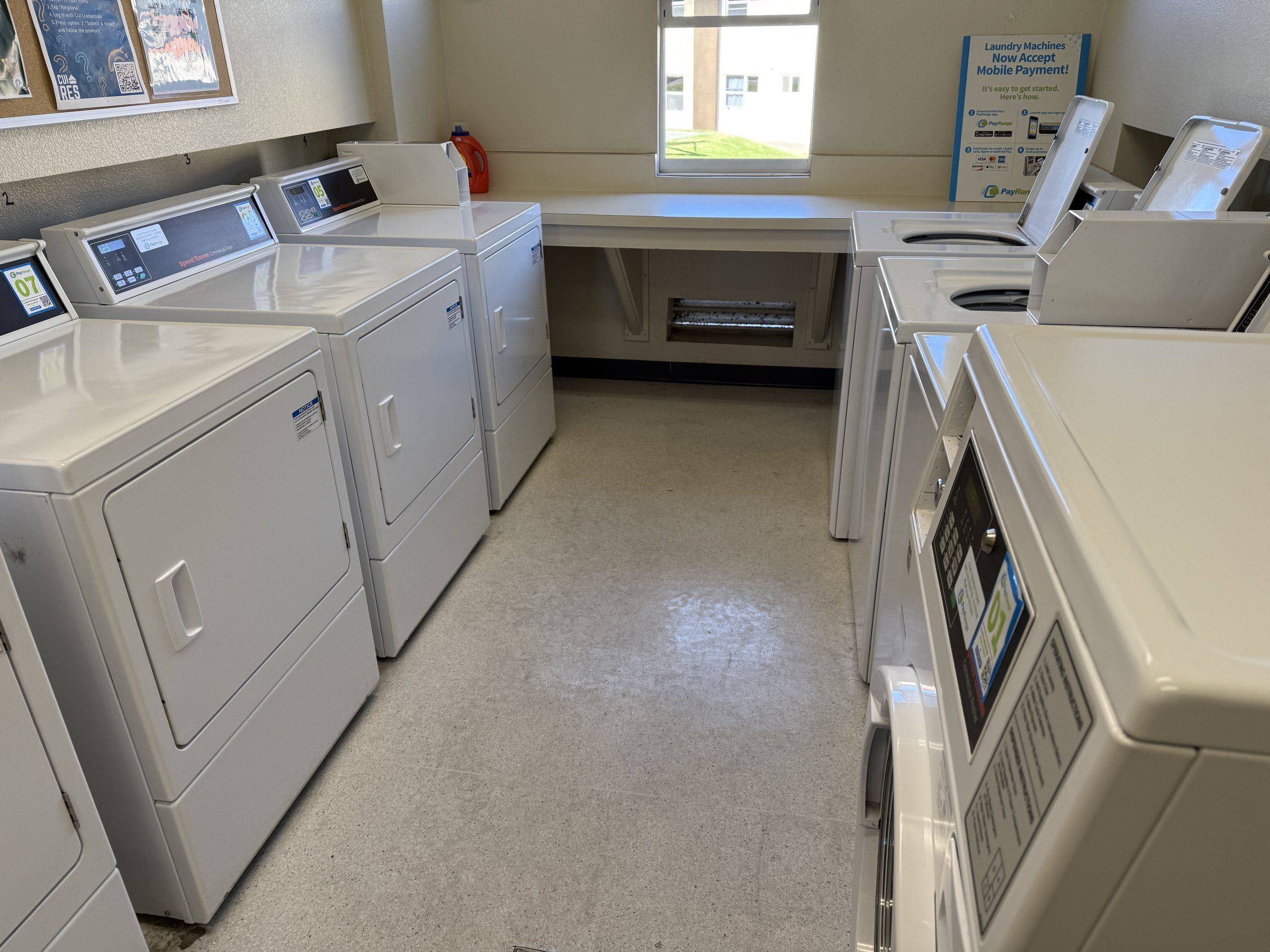 Washers and dryers with a folding counter in a Concordia residence laundry room