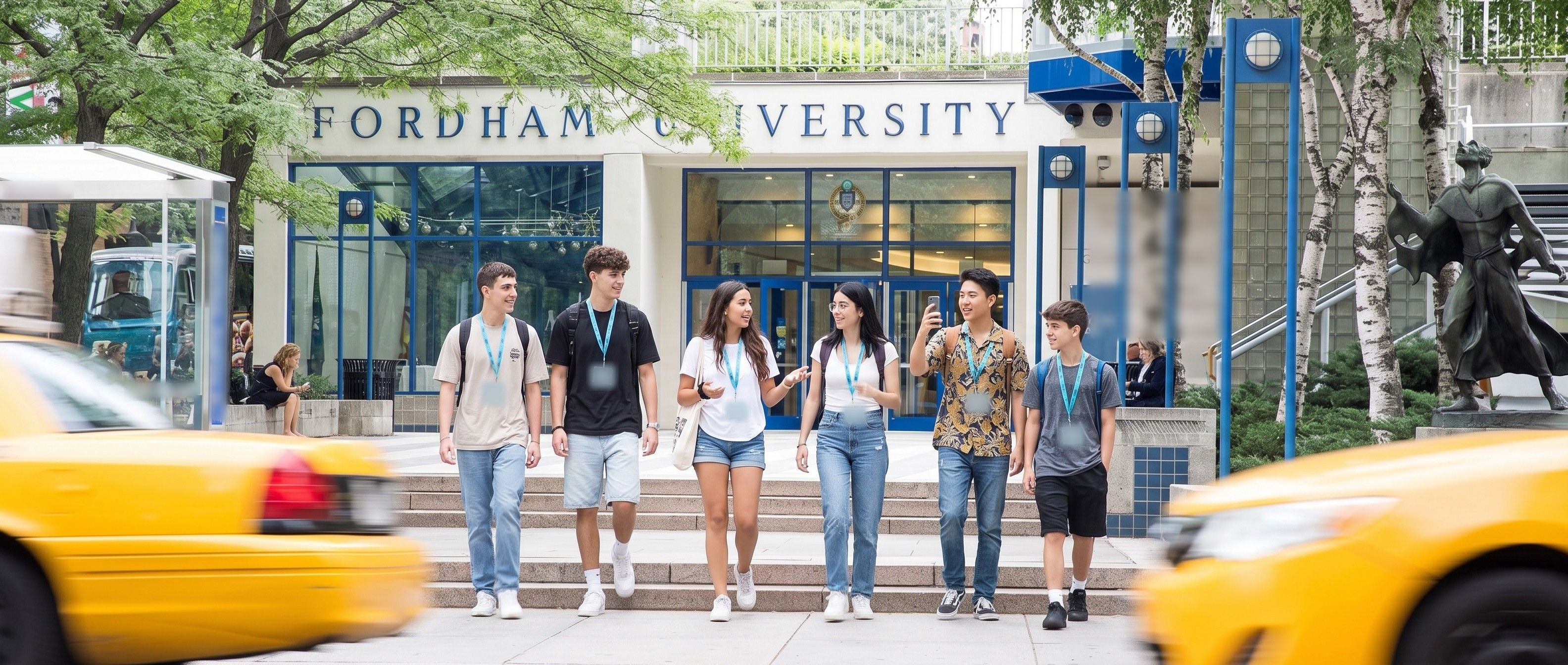 Students with YES USA lanyards walking down the steps of the Fordham University entrance at Lincoln Center, with yellow taxis passing