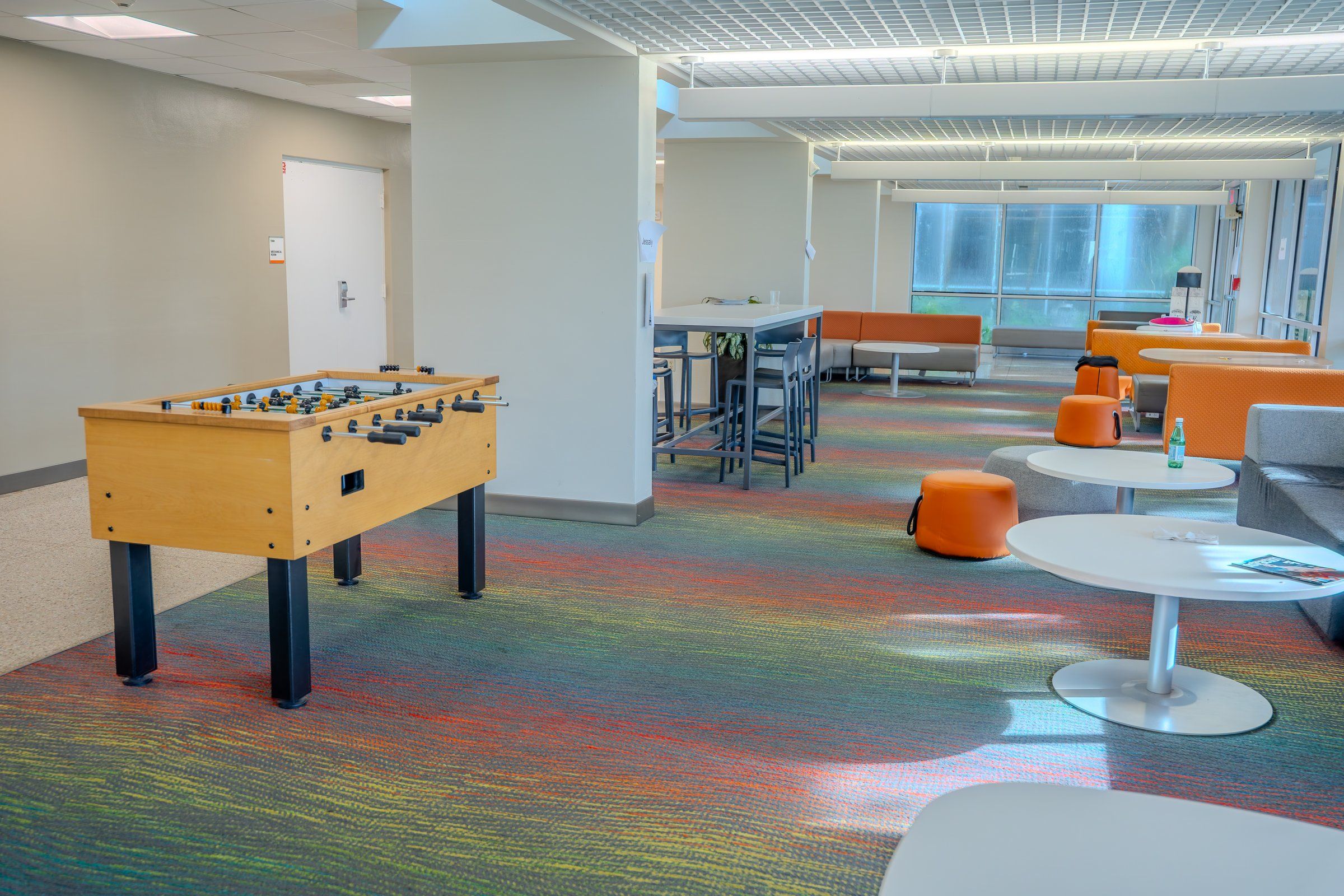 Residence lounge with a foosball table, tables and seating at the University of Miami