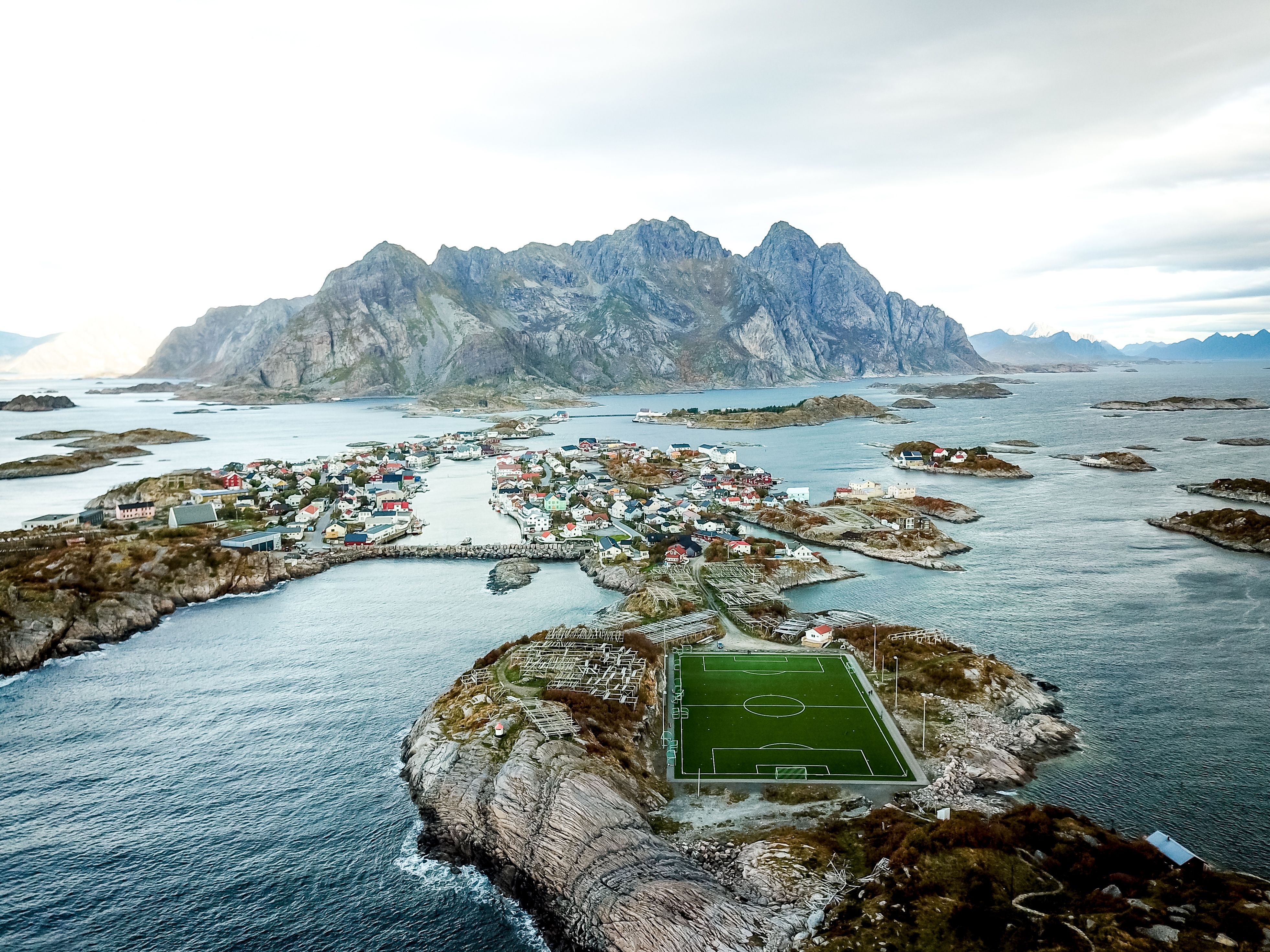 Bilde fra lofoten med en fotballbane og kysten