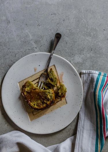 Picture of a slice of cake on a plate surround by a striped tea cloth.