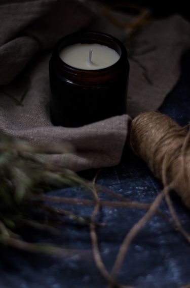 Candle on linen surrounded by natural thread