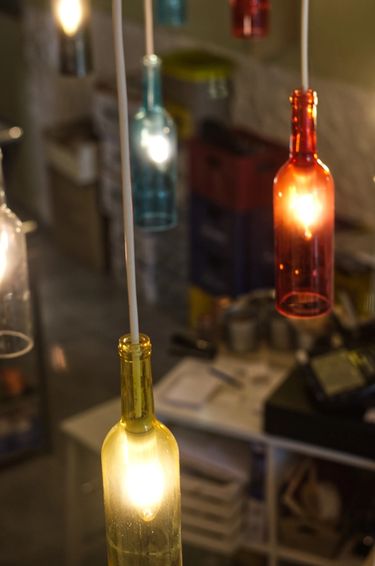 Hanging repurposed coloured bottles serving as lamp shades at a restaurant