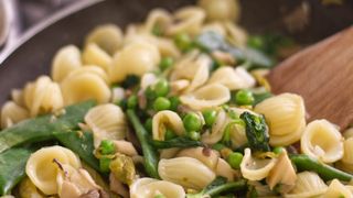Pasta with beans and peas in a pan on the stove 