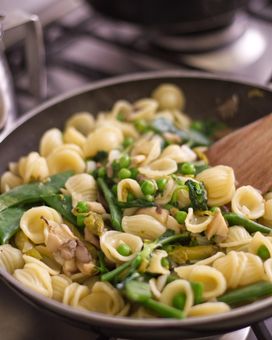 Pasta with beans and peas in a pan on the stove