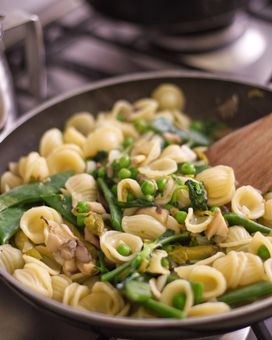 Pasta with beans and peas in a pan on the stove 