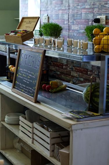Side shot of a cupboard decorated with candles, fresh fruit, signs and cutlery.